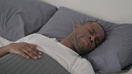 African Man Laying in Bed Unable to Sleep