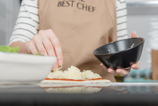 A Woman Prepares Margherita Pizza In Her Kitchen.