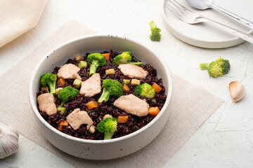 Healthy fried riceberry rice (brown jasmine rice) with chicken breast and broccoli carrot in white plate