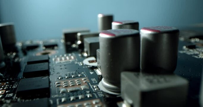 Macro dolly shot side view of a computer electrical circuit with cip, slots, microchip and microprocessors, board with transistors and microchips.Close up detail of electronic components on PC.