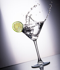 Glass with juice, ice and lime on a white gradient background