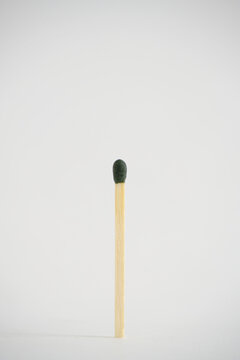A match with green head on a white background.