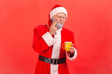 Portrait of elderly man with gray beard wearing santa claus costume suffering from terrible teeth...