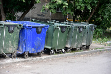 Garbage cans in the urban area and a landfill. Plastic garbage containers in the village.