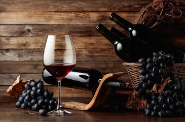 Fotobehang Red wine and blue grapes on an old wooden table. © Igor Normann