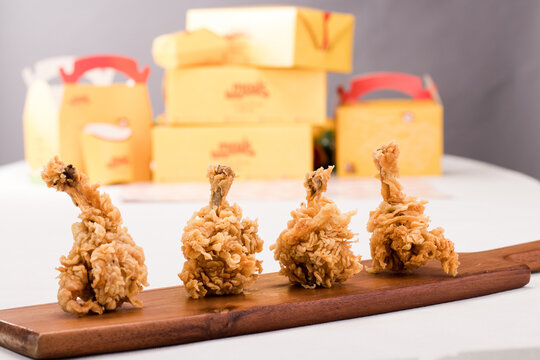 Crispy Chicken Lollipop isolated on wooden board side view on grey background fastfood
