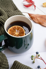 Cozy autumn composition, sweater weather. Pumpkins, hot tea and sweaters on window
