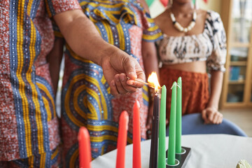 Fototapeta na wymiar Close-up of African family burning seven candles for Kwanzaa holiday to celebrate it at home