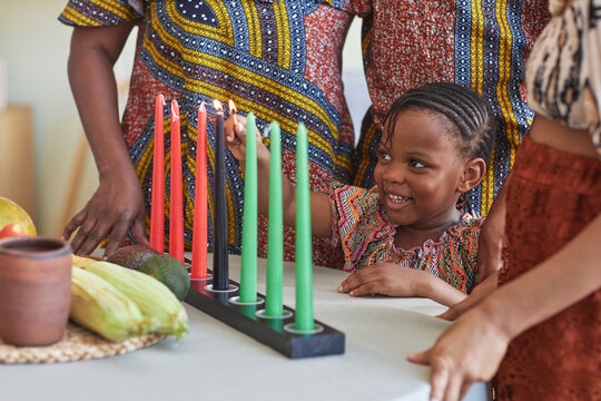 African Child Lighting Candles for Kwanzaa Holiday