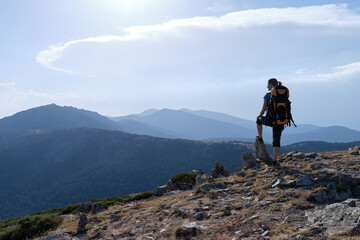 Naklejka na ściany i meble Female traveler with backpack admiring mountains