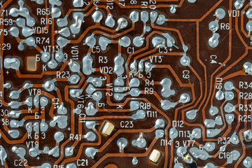 Old printed circuit board background. Vintage circuit board with soldering trace. Backside brown electronic chip retro style design