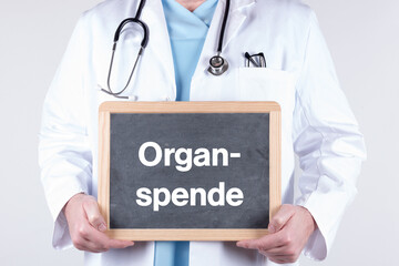 Arzt mit einer Tafel auf der Organspende steht