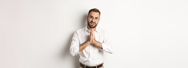 Worried man asking for help, begging for favour, standing over white background