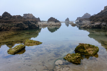 Fototapeta na wymiar Unique eroded sea rock formations on a gloomy foggy day on the Mediterranean Sea