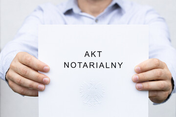 Notarial deed, Folder with an inscription in Polish and the national emblem, Held in hands, an official document confirming the performance of a specific legal act