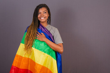 Young Afro Brazilian woman, LGBT flag, LGBTQ, bisexual. diversity. Lesbian. Hand on your chest to...