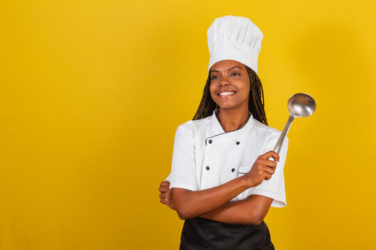 Young afro brazilian woman, chef cook, holding cooking ladle, kitchen accessory.