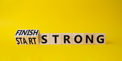 Start and Finish Strong. Turned wooden cubes with words Start and Finish Strong. Beautiful yellow...