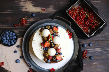 Vegan berry cake with coconut cream on wooden background.World Vegan Day. Dark hues for basis...