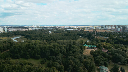 Obraz premium City with high-rise buildings. Park area in the foreground. Blue sky with clouds. Aerial photography.