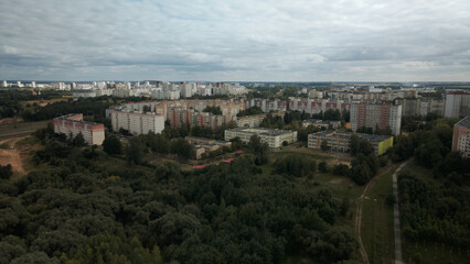 Obraz premium City with high-rise buildings. Park area in the foreground. Blue sky with clouds. Aerial photography.