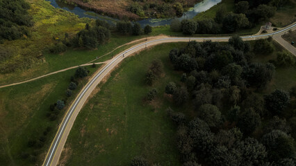 Winding bike path in the city park. City park at dawn. Aerial photography.