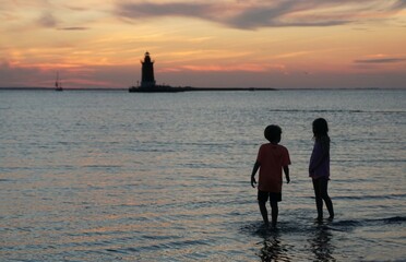 Silhouette of young kids enjoying the sunset at Cape Henlopen State Park, Lewes, Delaware, U.S © Khairil
