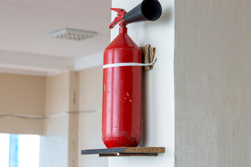 Portable hand-held fire extinguisher mounted on the wall inside the room