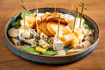 Cheese plate. delicious cheese mix with walnuts, honey on wooden table.