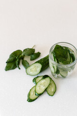 Summer refreshing drink with cucumber and basil. Cocktail in a glass on the table. High quality photo