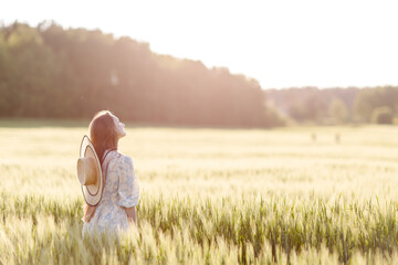 Trendy girl in stylish summer dress feeling free in the field in sunshine. High quality photo © Kanstantsinzzz