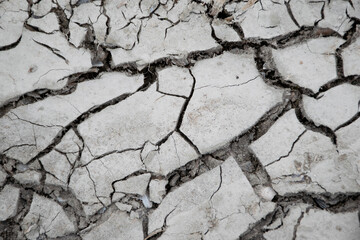 close up grey cracked and dried up soil. Global warming conceptual background. Dry lake close up, water shortage, environmental problem. 