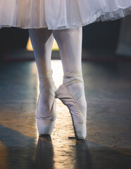 Ballet dancers couple during performance repetition, classic ballet rehearsal practicing in ballroom, view of legs in pointe shoes, ballerina and ballet dancer on a concert hall theatre stage © tsuguliev