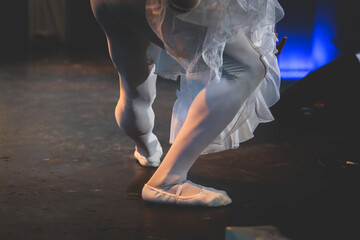 Ballet dancers couple during performance repetition, classic ballet rehearsal practicing in ballroom, view of legs in pointe shoes, ballerina and ballet dancer on a concert hall theatre stage © tsuguliev