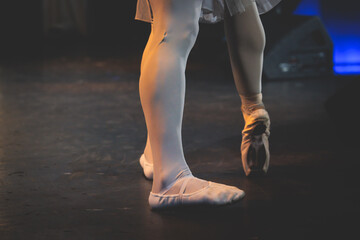 Ballet dancers couple during performance repetition, classic ballet rehearsal practicing in ballroom, view of legs in pointe shoes, ballerina and ballet dancer on a concert hall theatre stage