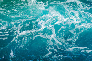 Turquoise abstract of sea surface with turbulent foamy water