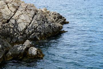A sharp, jagged big rock submerged in seawater