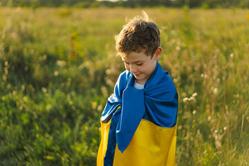 Ukraine's Independence Day. Ukrainian child boy in white t shirt with yellow and blue flag of Ukraine in field. Flag of Ukraine. Constitution day. Stand with Ukraine and Save