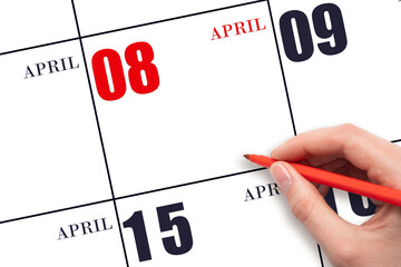 A hand holding a red pen and pointing on the calendar date April 8. Red calendar date, copy space,...