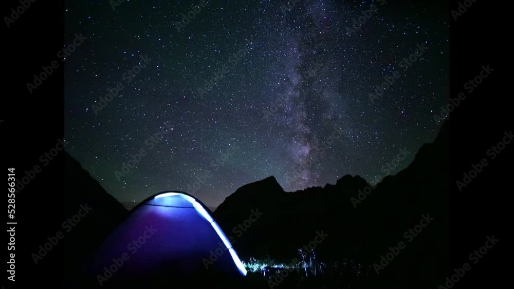 Sticker starlapse of milkyway with tent in the mountains