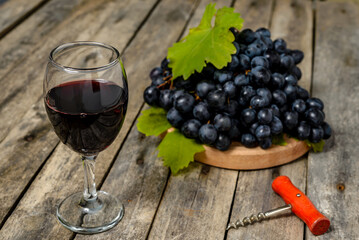 Red wine and grapes on wooden background