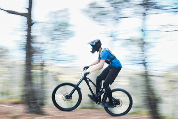 Fototapeta na wymiar Teenager in forest practicing downhill biking.