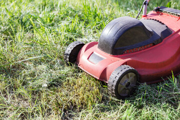 Lawnmower on green grass in the garden
