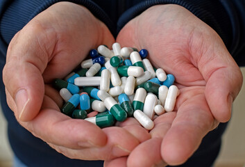 Assorted pills in male hands
