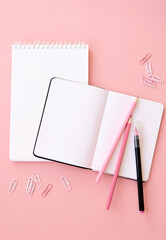 Back to school supplies stationery on pink background, flat lay, top view. Education creative accessories and open paper notebooks, pencils stuff. Stationary promotion flatlay from above, vertical.