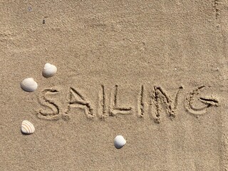 on the beach is carved with letters in the smooth sand the writing Sailing
