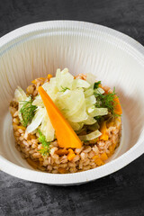 barley with pumpkin and fennel. a vegan dish in a plastic takeout container
