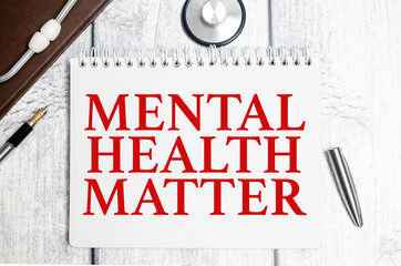 mental health matter words on notebook and stethoscope on white wooden background
