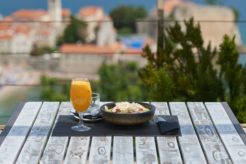 Fresh juice and food in a plate on the table in an outdoor restaurant