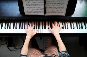 Fototapeta na wymiar Top view of hands playing piano